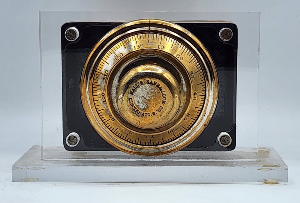Hall's Safe & Lock Co Safe Lock Mechanism Acrylic Display: Hall's is a company from Cincinnati, Ohio. The mechanism features a dial combination lock and cast metal body. It is worn due to age and use. Measures approximately 8" X 4_" X 5"