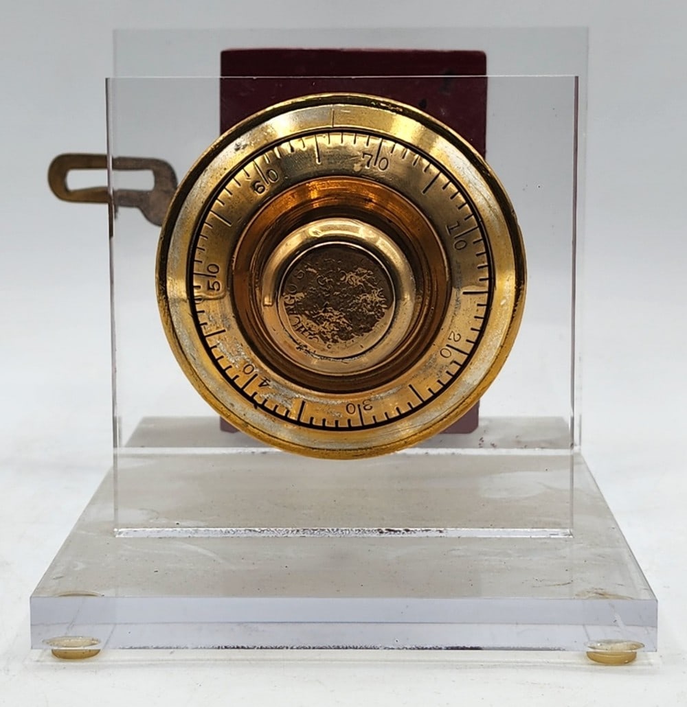 Chicago Safe & Lock Co Safe Lock Mechanism Acrylic Display: The mechanism has a cast metal body and dial combination lock. It uses a single bolt locking point system. Metal is worn due to age and handling. Measures approximately 7" X 8_" X 5_"