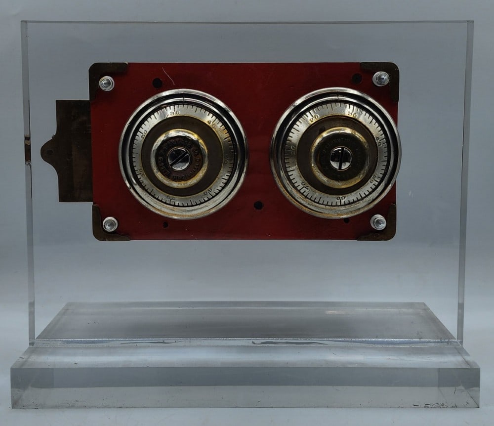 Hall's Safe & Lock Co Combination Lock Mechanism Acrylic Display: Hall's is a company from Cincinnati, Ohio. The mechanism features 2 combination dials and a single bolt locking point system. It has a cast metal body. Missing one back plate. Metal is worn due to age