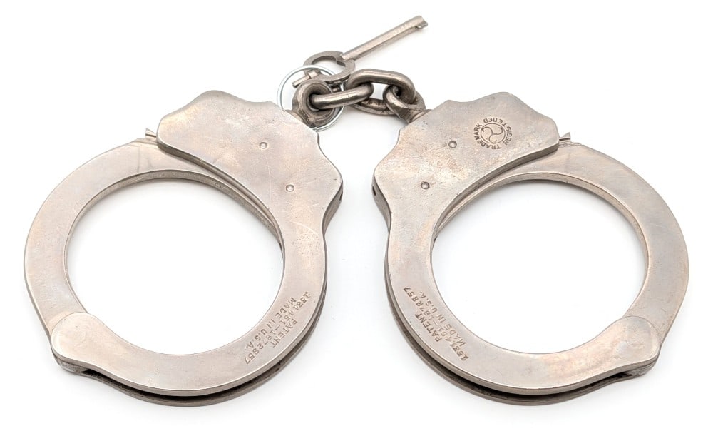 The Peerless Handcuff Co. Double Lock Handcuffs: The Peerless Handcuff Co. double lock handcuffs with key. The handcuffs show some scratches and light age wear.