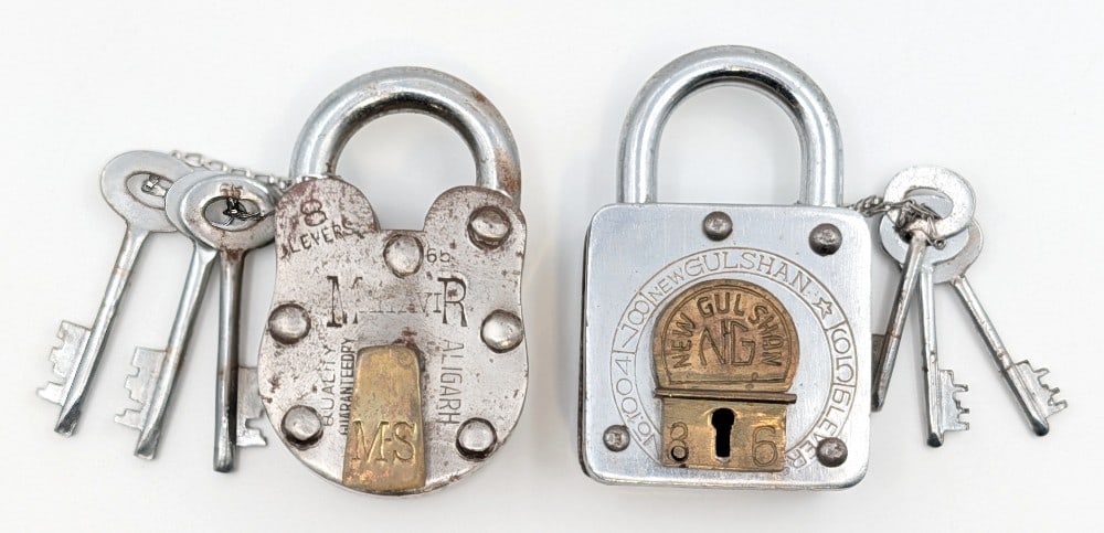 Mahavir Aligarh 8 Levers Padlock & New Gull Shan Padlock: Lot includes Mahavair Aligarh 8 levers padlock with keys and New Gull Shan padlock with keys. Both show some loss and wear from use and age. Largest measures 4" tall.