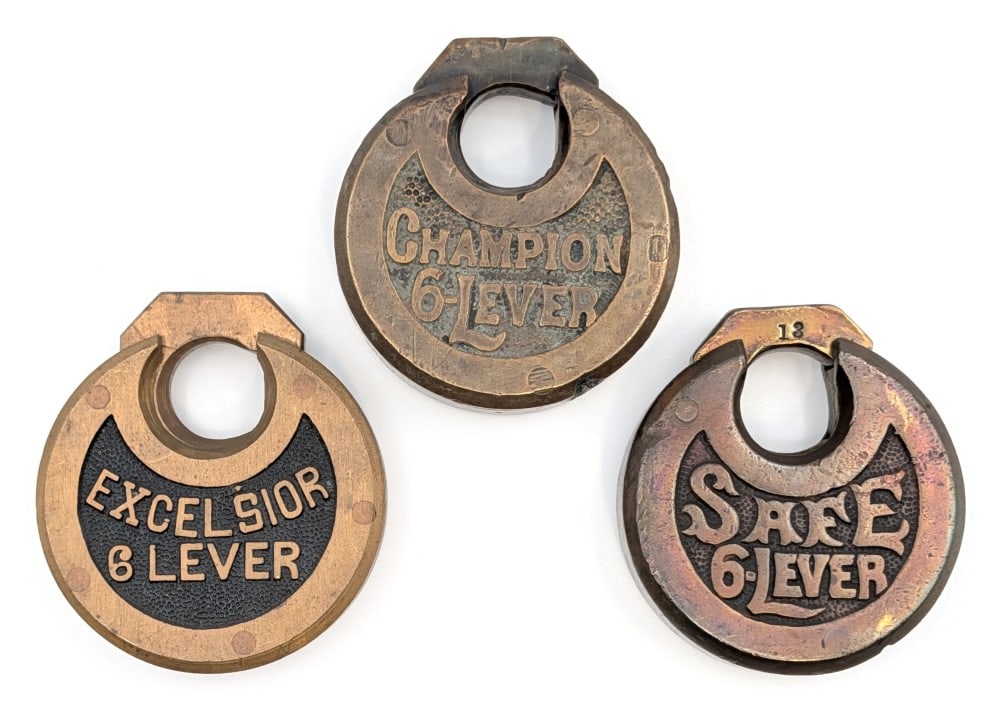 Excelsior 6-Lever, Safe 6-Lever, and Champion 6-Lever Padlocks: Excelsior 6-Lever, Safe 6-Lever, and Champion 6-Lever Padlocks. No keys included. All show wear from use and age. Each measures approximately 2-1/2" tall.