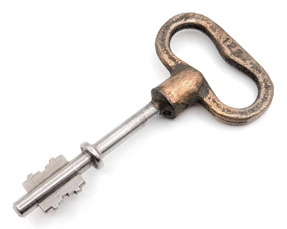 Antique Brass Spike Jail Key: Key has a brass handle stamped 123 on both sides. Key is in nice condition with pitting on the brass from the casting, and other wear from use and age. Measures 4-1/4in long.