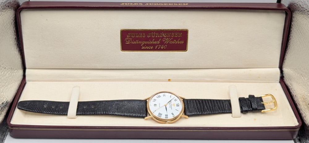 Men's Jules Jurgensen 14K Yellow Gold Roman Numeral Watch: Men's Jules Jurgensen 14k Yellow Gold Watch. The quartz movement watch has a white face with Roman numerals and a date window. The round case measures approximately 32mm in diameter. The case is solid