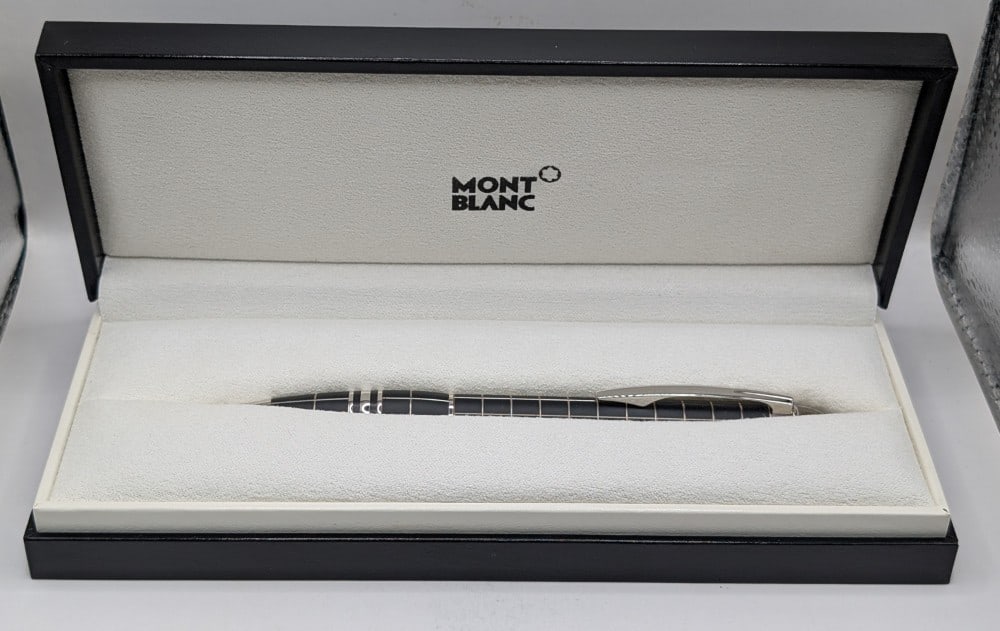 Montblanc Starwalker Metal & Rubber Ballpoint Pen #8857 In Box: Montblanc Starwalker Metal & Rubber Ballpoint Pen. The pen has a twist mechanism, black rubber like surface with metal lines, floating Montblanc emblem in a transparent cap top, platinum plated fittin