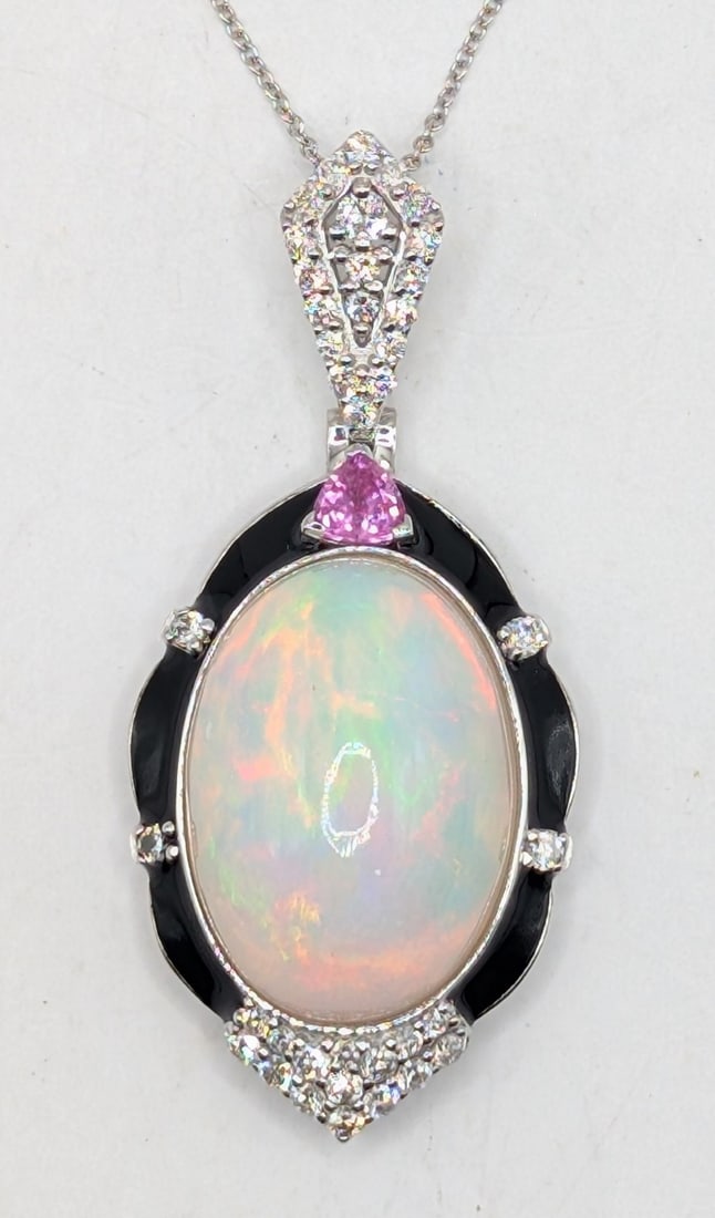 14K Gold Opal Sapphire & Diamond Pendant Necklace: 14K white gold pendant necklace with 12.44 CT natural opal, 0.29 CT pink Sapphire and (38) round cut diamonds totaling 0.60 CTS. Chain is 18" and total weight is 8.5 grams. Necklace comes with a Gemas