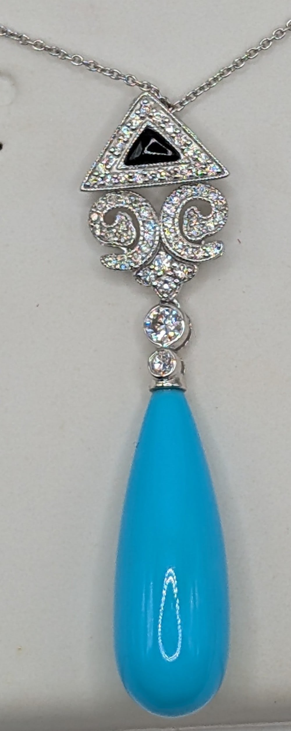 Platinum Turquoise & Diamond Pendant Necklace: Platinum pendant with11.90 CT drop shape turquoise and round cut diamonds totaling 0.45 CTS. Pendant is on 18" platinum chain and total weight is 6.9 grams. Necklace comes with a IAS jewelry appraisal