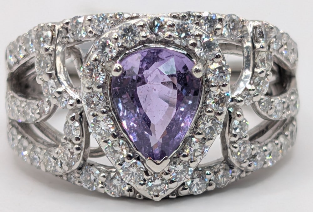 Platinum Sapphire & Diamond Ring: Platinum 1.29 CT pear cut purple sapphire and (58) round brilliant cut diamonds totaling 0.97 CTS. Ring is size 7 and weighs 10 grams. Ring comes with Gemassure gemological appraisal report with an es
