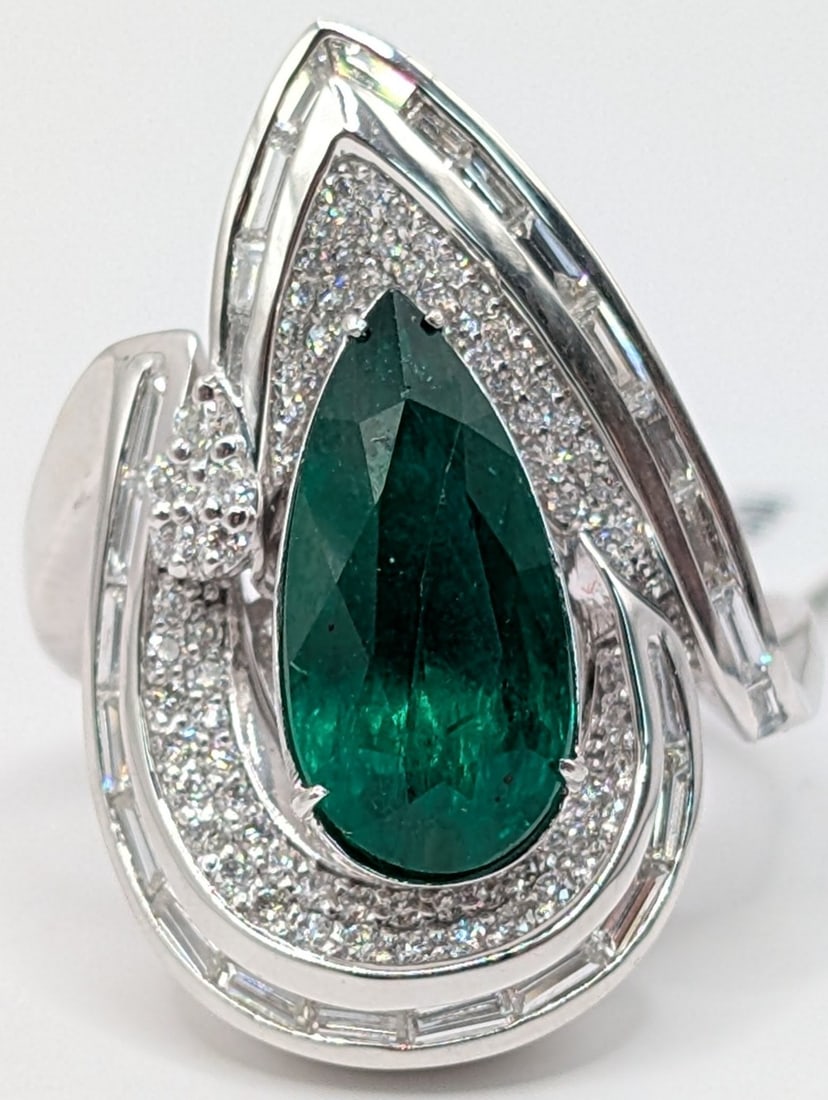 Platinum Pear Cut Emerald & Diamond Ring: Platinum ring with 3.16 CT pear cut emerald with (105) baguette & round cut diamonds totaling 0.90 CTS. Ring is size 7 and weighs 15.3 grams. Ring comes with an AIGL appraisal report with an
