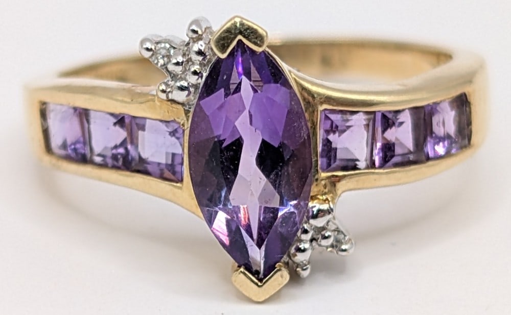 10K Yellow Gold Marquis Amethyst & Diamond Ring: 10k yellow gold ring with marquis cut purple amethyst center stone, diamond accents and princess cut channel set amethyst. Ring is size 7 and weighs 2.6 grams.