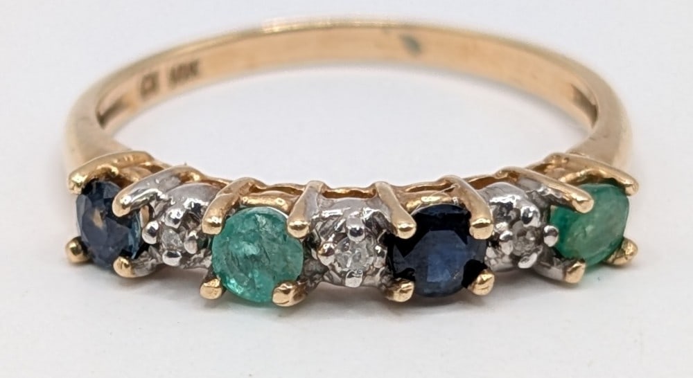 10K Yellow Gold Emerald Sapphire & Diamond Band: 10K yellow gold ring with round cut emerald, blue sapphire and diamonds. Ring is size 7 and weighs 1.7 grams.