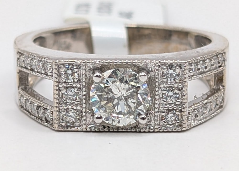 14K Gold Round Cut 1.02 Carat Diamond Center Stone Ring: 14K White Gold diamond ring with a center diamond of 1.02 carat. Ring has (26) round cut natural diamond adjacent stones that total 0.37 carats. The ring is size 10.5 and weighs 8.7 grams. Ring comes