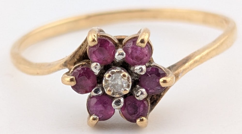 10K Gold Ruby & Diamond Floral Ring: 10K yellow ring with center diamond and ruby "petals". Ring is size 9 and weighs 1.4 grams.