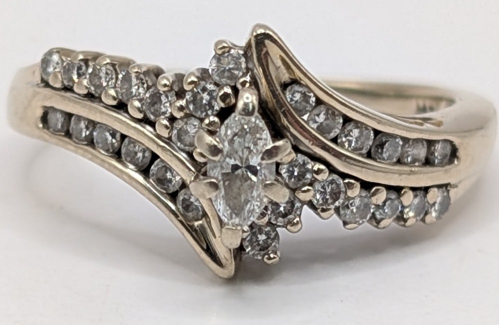 14K Gold Marquis Diamond Wedding Ring: 14K white gold swirl wedding ring with marquis diamond and round cut channel set diamonds on shank. Ring is size 6 and weighs 3.5 grams.