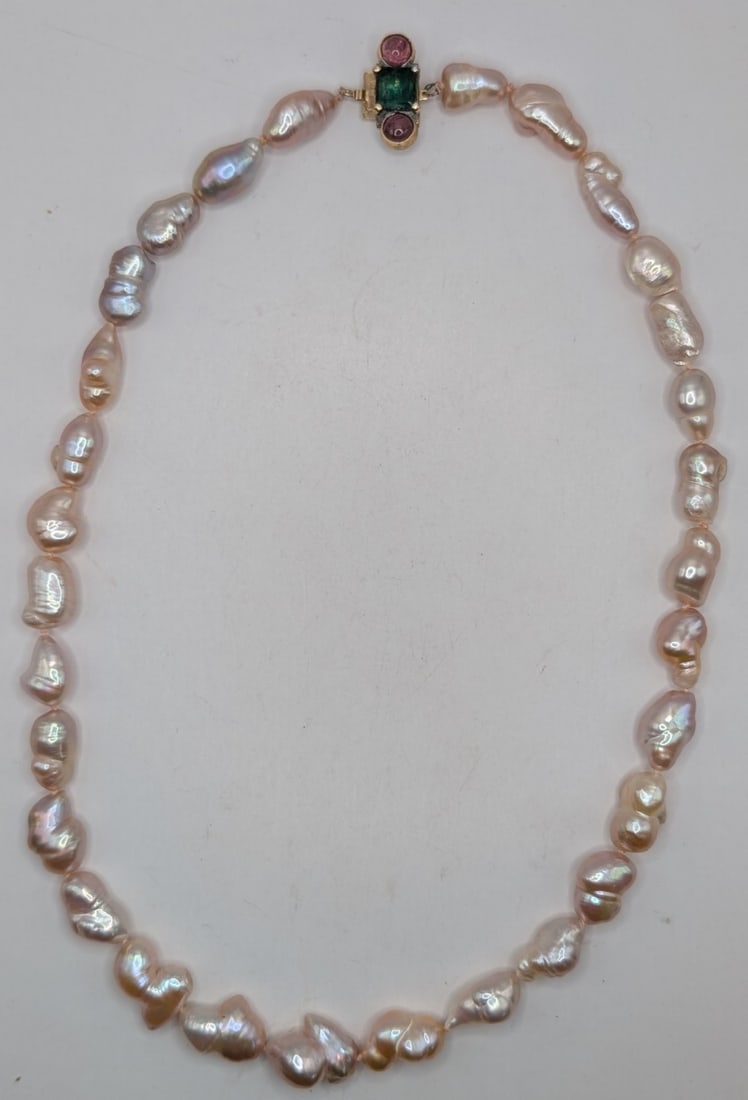 14K Gold Clasp Pink Pearl Necklace: 14K yellow gold clasp with emerald and rubies. Necklace has 30 hand tied pink pearls. Measures 16".