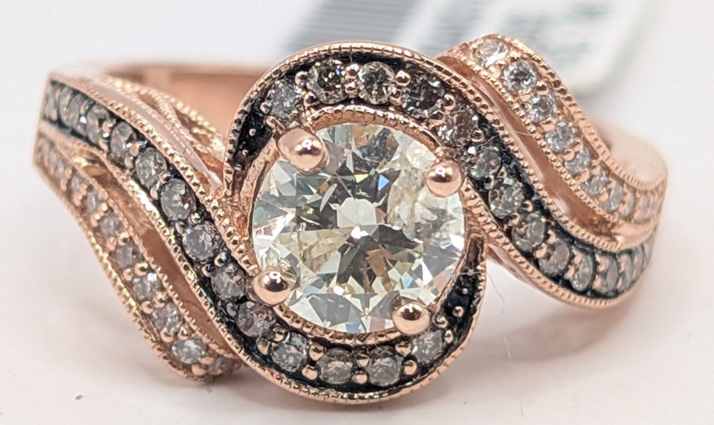 14K Rose Gold Levian Diamond & Chocolate Diamond Ring: Beautiful 14K rose gold Levian designer ring with round brilliant cut 1.01 carat diamond color grade K clarity grade I1. Swirling around the center diamond are (22) round cut white diamonds and (28)