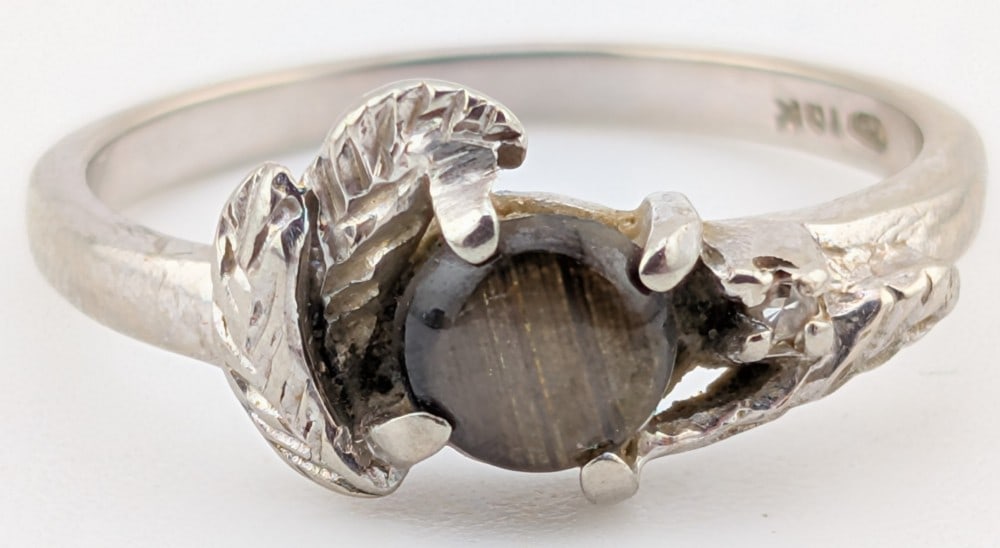 10K Gold Black Star Sapphire Ring: 10K white gold ring with round cabochon black Star Sapphire stone. Ring is size 6 and weighs 2 grams.