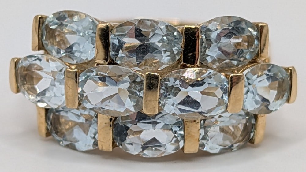 10K Gold Aquamarine Ring: 10K yellow gold ring with 10 stacked oval cut aquamarine stones. Ring is size 8 and weighs 3.7 grams.