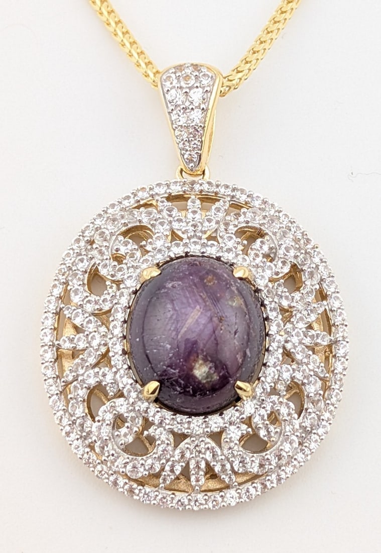 Sterling Gold Plate 24.71 cts Ruby & White Sapphire Pendant Necklace: Sterling/gold overlay pendant with 24.71 cts natural oval cabochon Ruby and (212) 3.90 ctw round cut white sapphires. The pendant is on an 18" sterling silver gold overlay chain. The total weight is 2