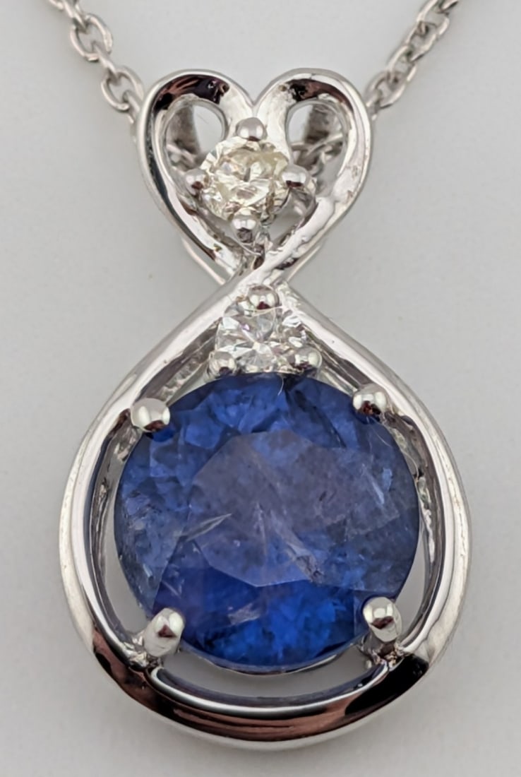 Sterling 1.64 ctw Tanzanite & Diamond Pendant Necklace: Sterling silver pendant with 1.64 ctw round cut tanzanite and two round brilliant cut diamonds. The pendant is on 18" sterling silver chain. The total weight is 2.2 grams. Necklace comes with a GGA je