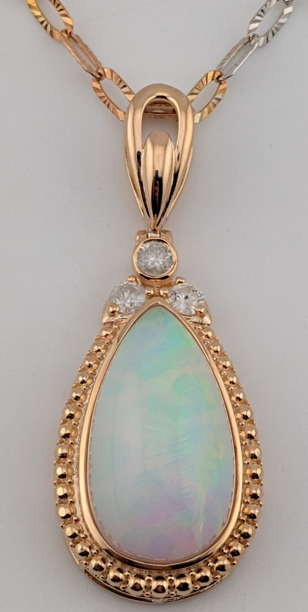 Sterling/18K Gold Overlay 10.81 ctw Opal & Diamond Pendant Necklace: Sterling/18K gold overlay pendant with 10.81 ctw natural opal and three round brilliant cut diamonds .31 ctw. The pendant is on a tri-color 18" sterling silver chain. The total weight is 9.3 grams. Ne