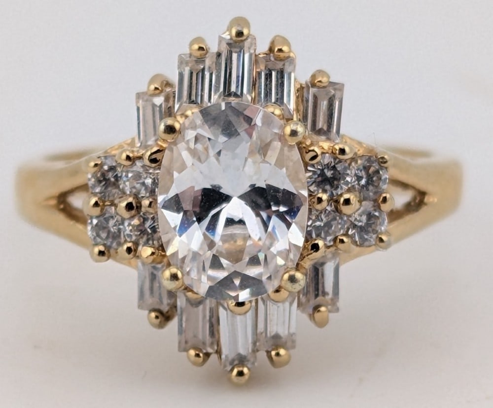 Sterling Gold Tone White Sapphire Ring: Sterling silver gold tone ring with oval, baguette and round cut white sapphires. Ring is size 7 and weighs 4.2 grams.