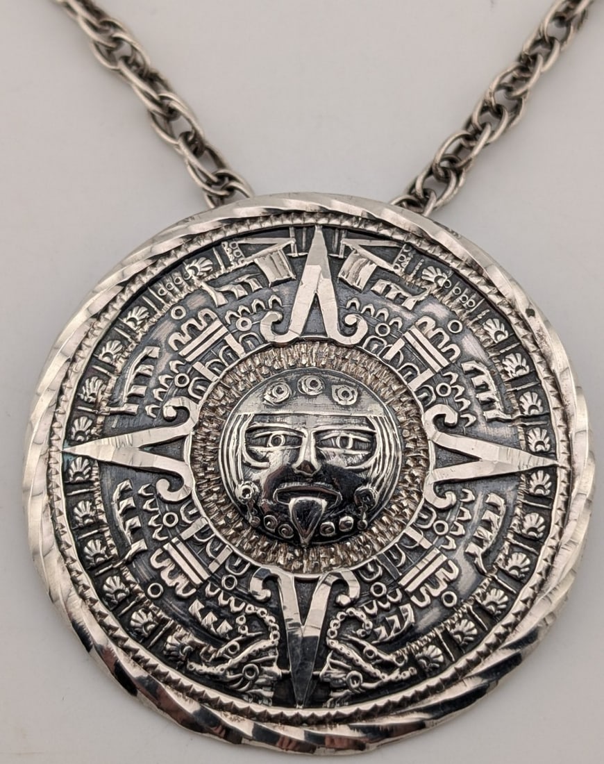 Vintage Sterling Mexico Mayan Sun God Calendar Pendant Necklace: Vintage Sterling silver made in Mexico Mayan sun god calendar Pendant. Pendant measures 2.5" in diameter and is on a 28" sterling silver chain. Total weight is 40.8 grams.