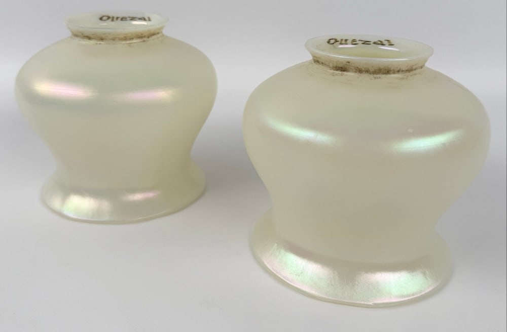 Pair Of Signed Quezal Art Glass Pearl Iridescent Lamp Shades: Pair Of Signed Quezal Art Glass Pearl Iridescent Lamp Shades. The shades have 2-1/4" fitters. One is in great condition, the other is in good condition, but has some chips at the edge of the fitter, h