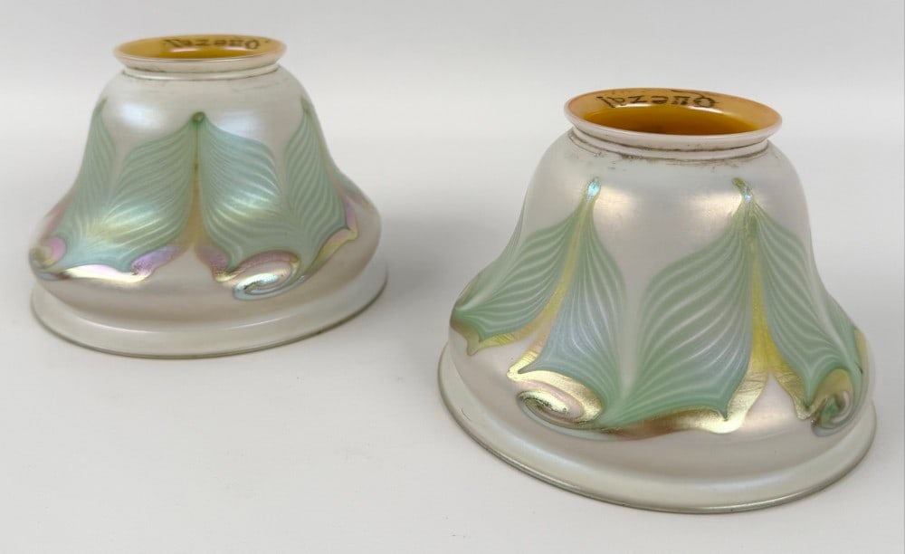 Pair Of Signed Quezal Art Glass Pearl & Gold Iridescent Lamp Shades With Green Pulled Feathers: Pair Of Signed Quezal Art Glass Pearl & Gold Iridescent Lamp Shades With Green Pulled Feathers. The shades have 2-1/4" fitters and are in good condition. Overall they measure approximately 2-1/4" tall