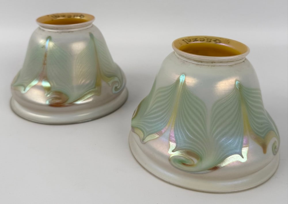Pair Of Signed Quezal Art Glass Pearl & Gold Iridescent Lamp Shades With Green Pulled Feathers: Pair Of Signed Quezal Art Glass Pearl & Gold Iridescent Lamp Shades With Green Pulled Feathers. The shades have 2-1/4" fitters and are in good condition. Overall they measure approximately 2-1/4" tall