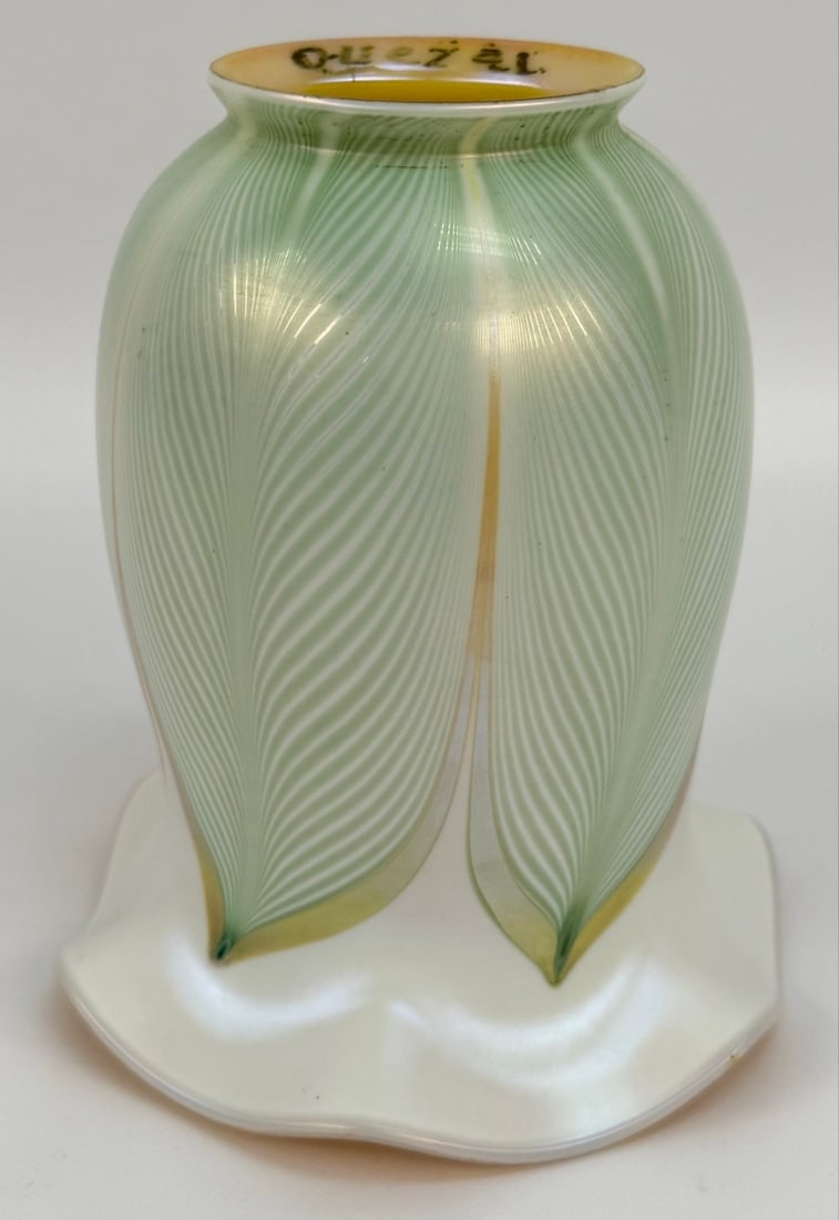 Signed Quezal Art Glass Pearl & Gold Iridescent Lamp Shade With Green Pulled Feathers: Signed Quezal Art Glass Pearl & Gold Iridescent Lamp Shade With Green Pulled Feathers. The shade has a 2-1/4" fitter and is in good condition. Overall measures approximately 5-1/4" tall x 4-1/2" acros