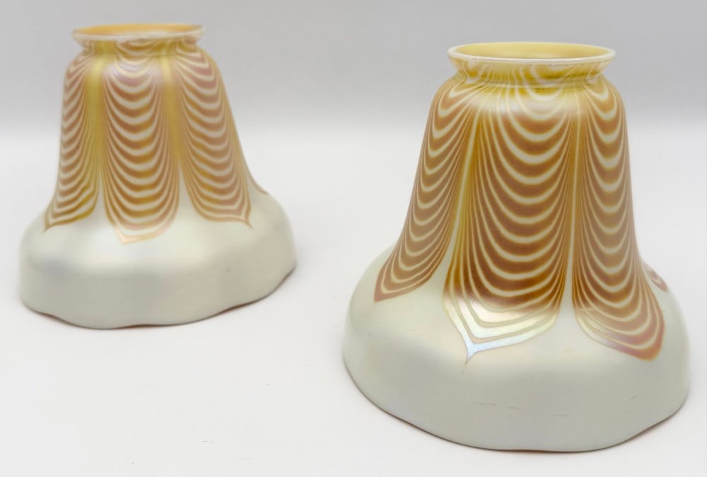 Pair Of Steuben Pearl & Gold Iridescent Art Glass Lamp Shades With Gold Pulled Feathers: Pair Of Steuben Pearl & Gold Iridescent Art Glass Lamp Shades With Gold Pulled Feathers. The shades have 2-1/8" fitters and are in good used condition, one shade has a couple flea bites on the fitter,