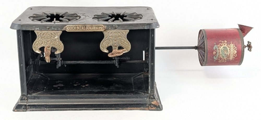 Early Quick Meal Junior 622 Gravity Fed Portable Camp Stove: Stove is in good condition with a nice painted graphic on the tank, both of the removeable grates, and scattered paint chips and wear from use and age. One of the grates is broken in half. Measures wi