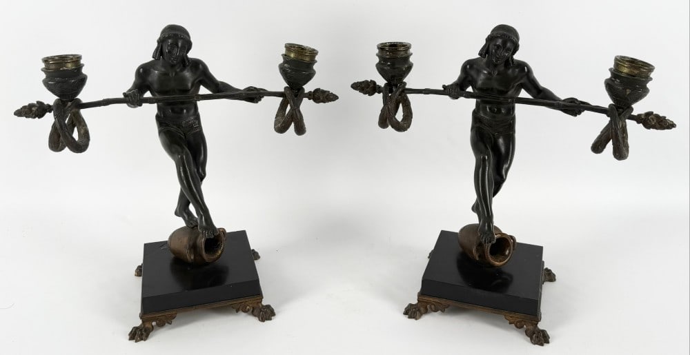 Pair Of Antique Bronze Figural 2-Light Candleholders By Emile Carlier: Pair Of Antique Bronze Figural 2-Light Candleholders By French Sculptor Emile Carlier. The candleholders feature semi-naked male Egyptian entertainers balanced on one leg standing on an urn. They feat