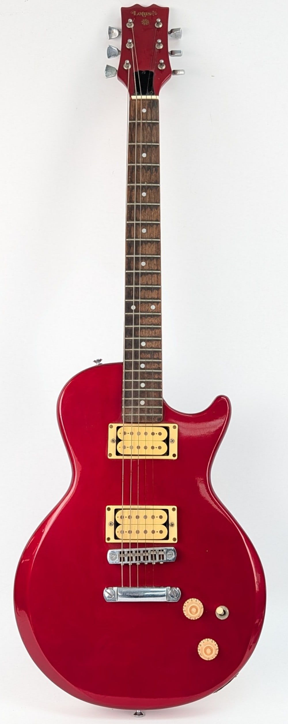 1970's Lotus Les Paul Copy Solid Body Electric Guitar: 1970's Lotus Les Paul Copy Solid Body Electric Guitar. The guitar has a? brick red color body with silver-tone hardware, selector switch, and a bolt on neck. Measures approximately 39-3/4" tall x 12-1