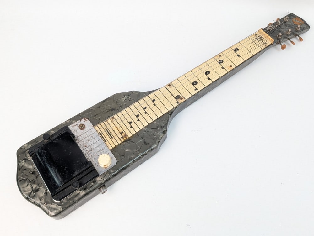 1950's National Chicagoan Lap Steel Electric Guitar: 1950's National Chicagoan Lap Steel Electric Guitar. The guitar has a grey pearloid finish body, single-coil pickup, volume & tone controls, and a plastic cover over the fret board. Measures approxima