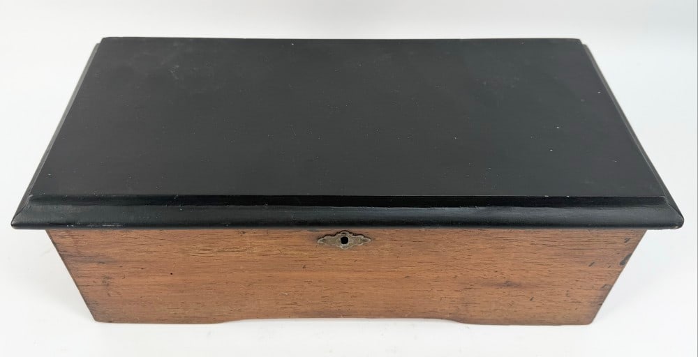 Antique Swiss Cylinder Music Box: Antique Swiss Cylinder Music Box. The music box works and all the teeth are present. Comes in a wooden cabinet. Displays well with age and use wear. Measures approximately 5-1/2" tall x 15" across x 7