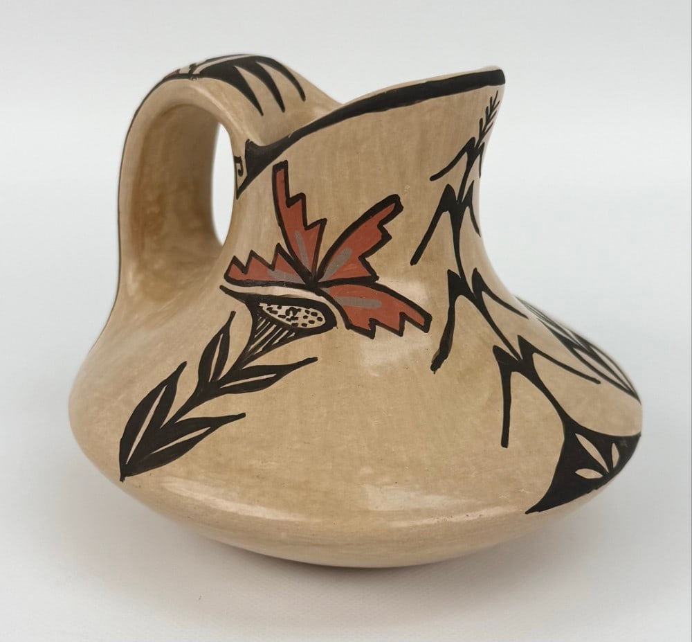 Juanita Fragua Jemez Pueblo Polished Pottery Creamer: Pottery Creamer by listed Jemez Pueblo artist Juanita Fragua (1935-2023). The polychrome pottery creamer features geometric and flower designs. Signed on the base. Great condition with no chips or cra