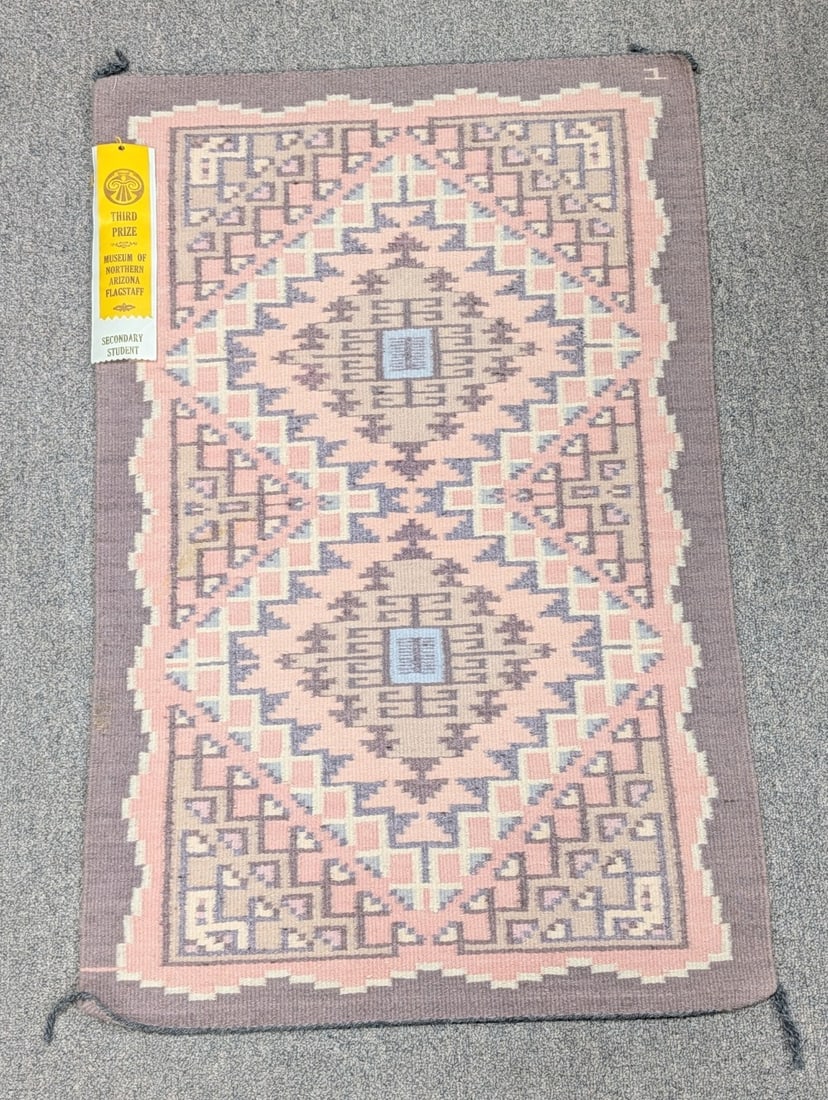 Navajo 36" x 23" Woven Wool Rug By Cherileen Teasyatwho: Navajo 36" x 23" Woven Wool Rug By Cherileen Teasyatwho. The rug features light orange, tan, and brown colors with a geometric design. The maker received a 3rd place ribbon for the rug at the 1993 Nav