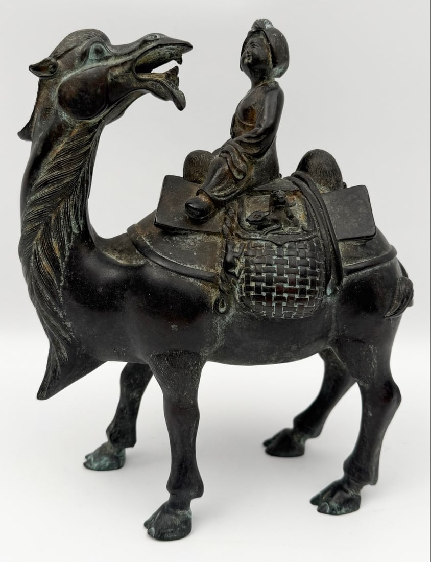 Antique Chinese Wang Zhaojun Goes To The Frontier Patinated Bronze Statue: Antique Chinese Wang Zhaojun Goes To The Frontier Patinated Bronze Statue. The piece has intricate detail of a camel and rider. Good condition with some age and display wear. Measures approximately 9"
