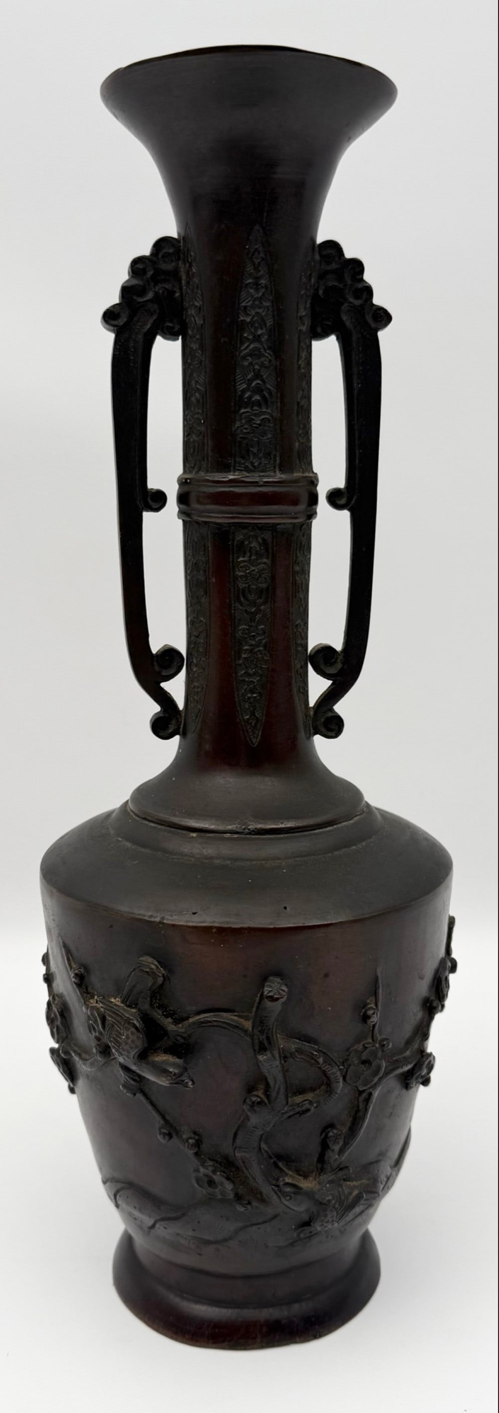 Japanese Meiji Period Birds In Relief Bronze Vase: Japanese Meiji Period Bronze Vase. The vase features birds, branches and flowers in relief, great detail. Excellent condition and measures 12-3/4" tall x 4-1/2" across.