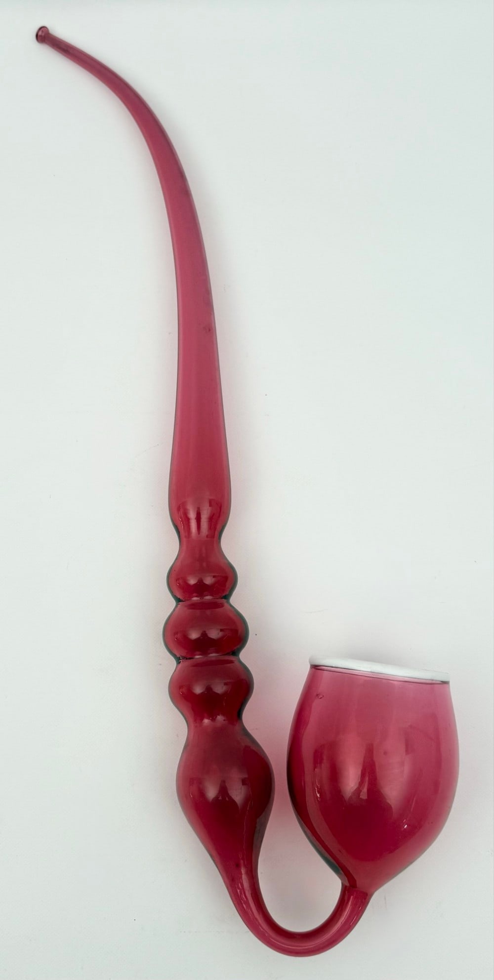 Large Victorian Cranberry Glass Pipe: Large Victorian Cranberry Glass Pipe. The pipe has a deep bowl with a white glass rim connected to an upturned neck followed by four knobs and an elongated tapered stem. Excellent condition with no ch