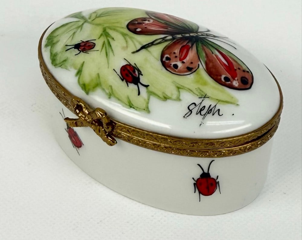 Signed Eximious Peint Main Limoges France Butterfly & Ladybug Trinket Box: Signed Eximious Peint Main Limoges France Butterfly & Ladybug Trinket Box. Nice box artist signed "Steph". Measures approximately 1-1/4" tall x 2-1/2" across x 1-1/2" deep. Great condition hand-painte
