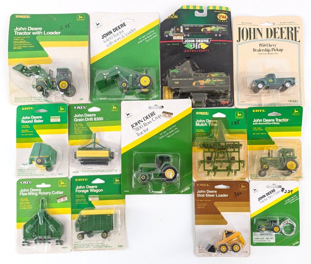 (13) 1/64 John Deere Tractors, Implements, Keychain, and Semi: (13) 1/64 Ertl John Deere tractors, implements, pickup truck, key chain, and 1/144 scale semi truck with trailer. All are in the packages. The packages show dust and wear from storage / display.