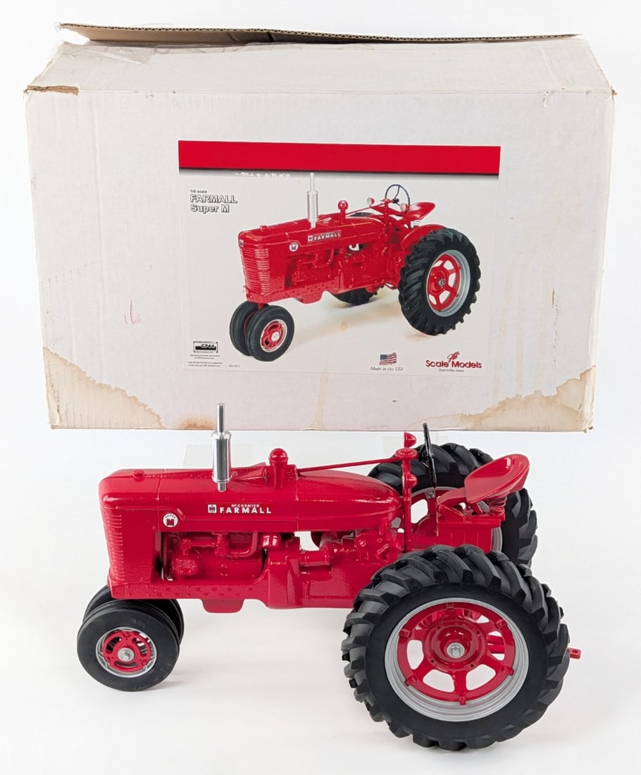 1/8 Scale Models Farmall Super M Narrow Front Tractor: 1/8 Scale Models Farmall Super M narrow front tractor. The tractor doesn't have the fenders. Otherwise in good condition in the box. The box has some water damage and wear from storage.
