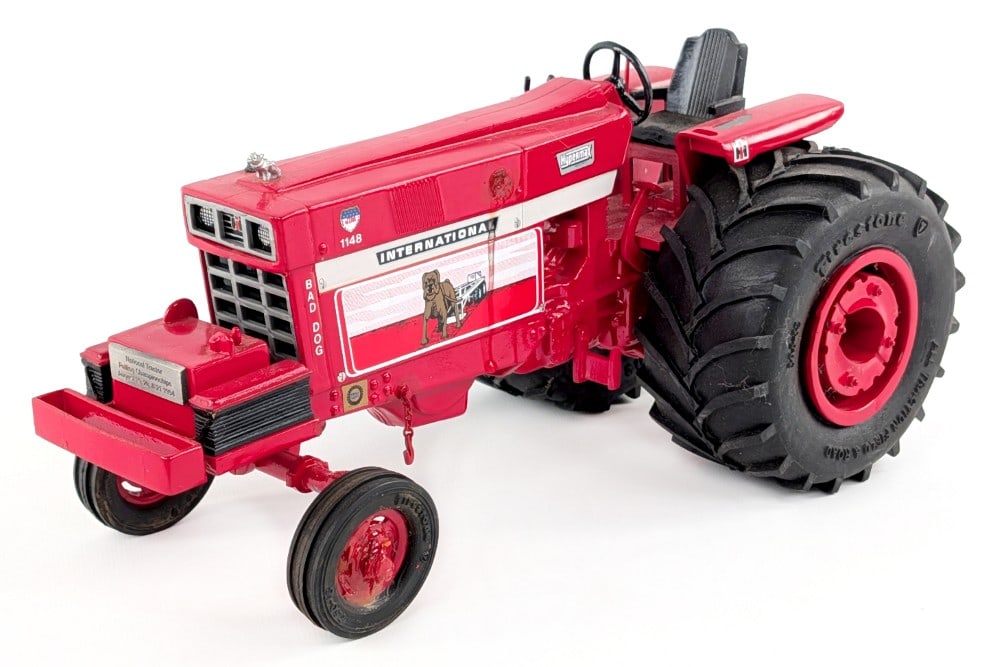 Custom 1/16 International Bad Dog Pulling Tractor: Custom 1/16 International Bad Dog pulling tractor. The tractor has damage to the one wheel and paint loss to the one fender. It is missing the exhast stack that would have came out of the hood. It has