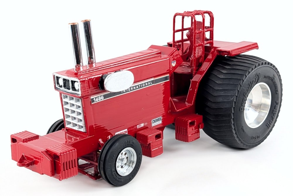 Custom 1/16 International 1486 Pulling Tractor: Custom 1/16 International 1486 pulling tractor. The tractor displays well with custom roll cage, chrome exhaust stacks, tires, and suitcase weights. The brake pedals appear to be starting to crack, bu