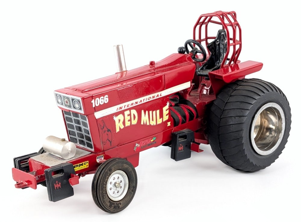 Custom 1/16 International 1066 Red Mule Pulling Tractor: Custom 1/16 International 1066 Red Mule pulling tractor. The tractor has a repair to one of the rear wheelie bars and some corrosion one of the front axle spindles. The tractor has a custom roll cage,