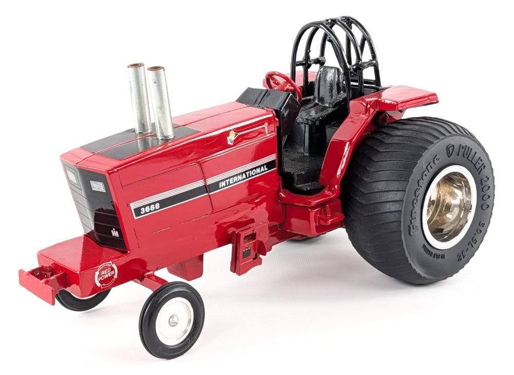Custom 1/16 International 3688 Pulling Tractor: Custom 1/16 International 3688 pulling tractor. The tractor has custom tires, roll cage, suitcase weights, and exhaust stacks. It has some light dust from display / storage.