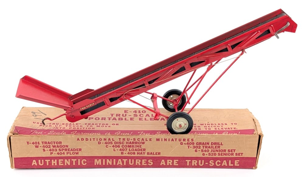 1/16 Tru-Scale Portable Elevator w/ Box: 1/16 Tru-Scale portable elevator with the original box. The elevator has some paint loss on the hitch, minor rub marks, and crazing on the chute. The box has some writing on it and edge wear from stor